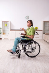 Young male invalid in wheel-chair suffering at home