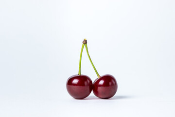 Cherry on a white background. Two red cherries on one branch
