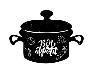 Lettering of phrase Bon Appetit on black pan with vegetables