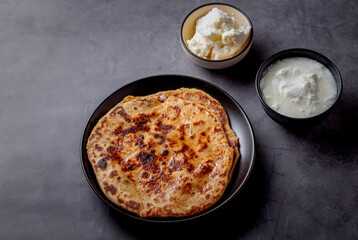 Aaloo parantha or stuffed potato flatbread with curd and white butter