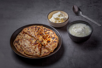 Aaloo parantha or stuffed potato flatbread with curd, pickle and homemade white butter