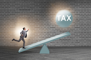 Businessman in tax concept with seesaw