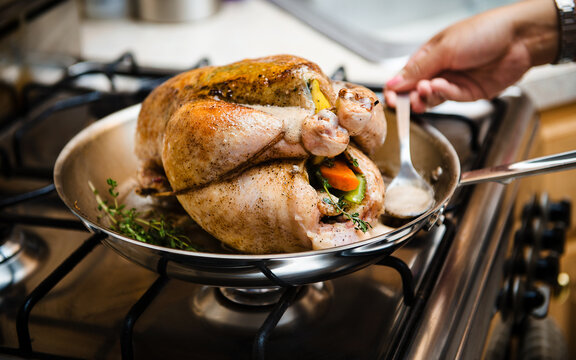 roast chicken with stuffed vegetables cooking in a pan
