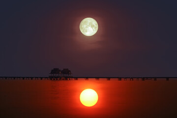 reflection of sunset  silhouette bridge and pavillion in sea and full moon on the sky