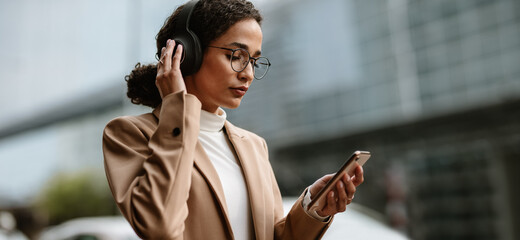 Businesswoman using truly wireless headphones while commuting