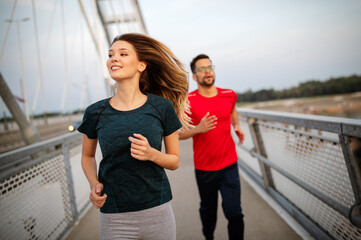 Beautiful couple running in nature living healthy