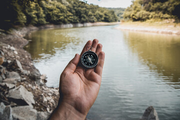 hand holding a fishing rod, the compass in my hand, the lake