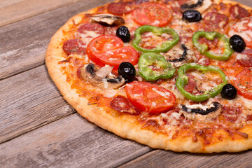 Pizza with a variety of topping on ole wood background