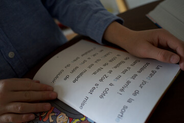 Child looking at open book in French language - learning to read