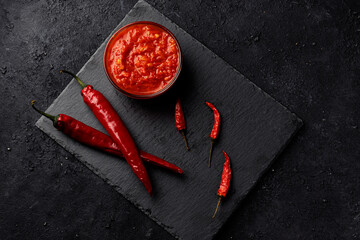 Traditional Maghribi with hot pepper and harissa pepper sauce. Tunisia and ajika arabic cuisine on black background