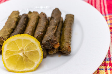 Sarma is a Turkish Traditional famous food on grape leaves. Turkish foods;(yaprak sarma dolma) stuffed leaf stuffed rice on plate served with lemon