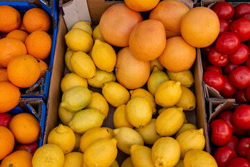 Oranges and lemons close up in boxes on a shop window in an open city market.