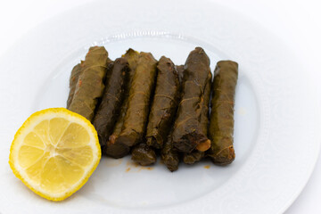 Sarma is a Turkish Traditional famous food on grape leaves. Turkish foods;(yaprak sarma dolma) stuffed leaf stuffed rice on plate served with lemon