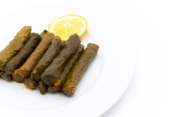 Sarma is a Turkish Traditional famous food on grape leaves. Turkish foods;(yaprak sarma dolma) stuffed leaf stuffed rice on plate served with lemon