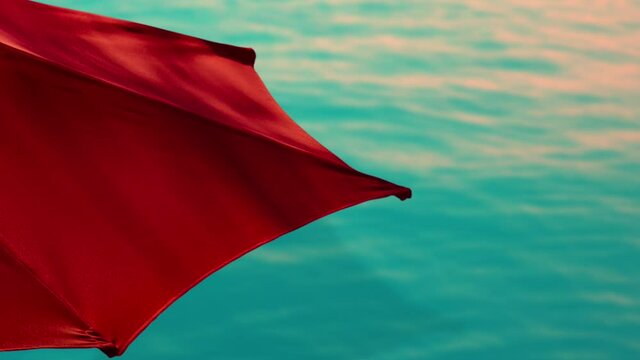 Vibrant Red Parasol Against Tropical Blue Ocean Water