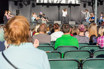 Rear view of audience at open air theatre in city center.