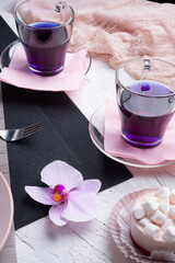 life style set at meeting in cafe.Thai blue, Butterfly pea tea served with fresh figs and panna cotta cake and fruit piece of cake on serving napkins.