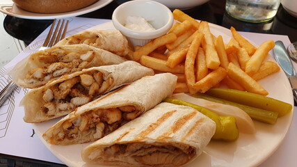 Flat bread with chopped chicken. Fried potatoes, pickles.