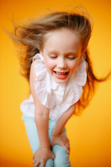 Young girl with plain pure sking and strong blonde fair hair. Hand on hairs. Little girl smiling in camera. Beautiful Studio portait of young child. 