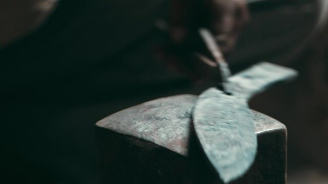 Hot metal knife piece hammered on a square anvil
