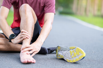 Young adult male with his muscle pain during running. runner man having leg ache due to Ankle Sprains or Achilles Tendonitis. Sports injuries and medical concept - obrazy, fototapety, plakaty