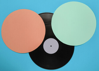 Retro vinyl record on blue color background with orange green circles. Retro minimalism. Top view