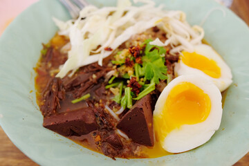 Northern Thai Rice noodles with spicy pork sauce with Boiled eggs and Bean sprouts in white bowl is local food culture in Thailand