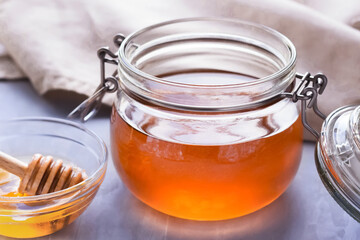 honey in a glass jar on a gray background
