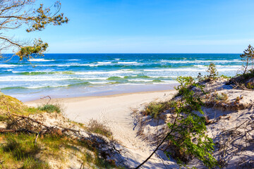 Entrance to beautiful white sand beach with blue sea near Kolobrzeg, Baltic Sea coast, Poland