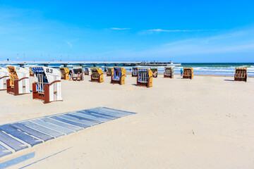 Obraz na płótnie Canvas KOLOBRZEG PORT, POLAND - MAY 31, 2020: Beach chairs on white sand beach in Baltic Sea coastal town of Kolobrzeg, Poland.