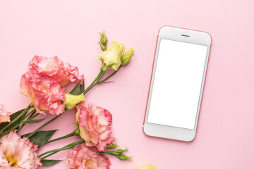 Mobile phone and pink flower bouquet on pastel background
