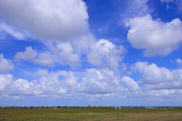 Panorama an der Nordsee von D&uuml;nen mit Strandk&ouml;rben und Wolken am blauen Himmel