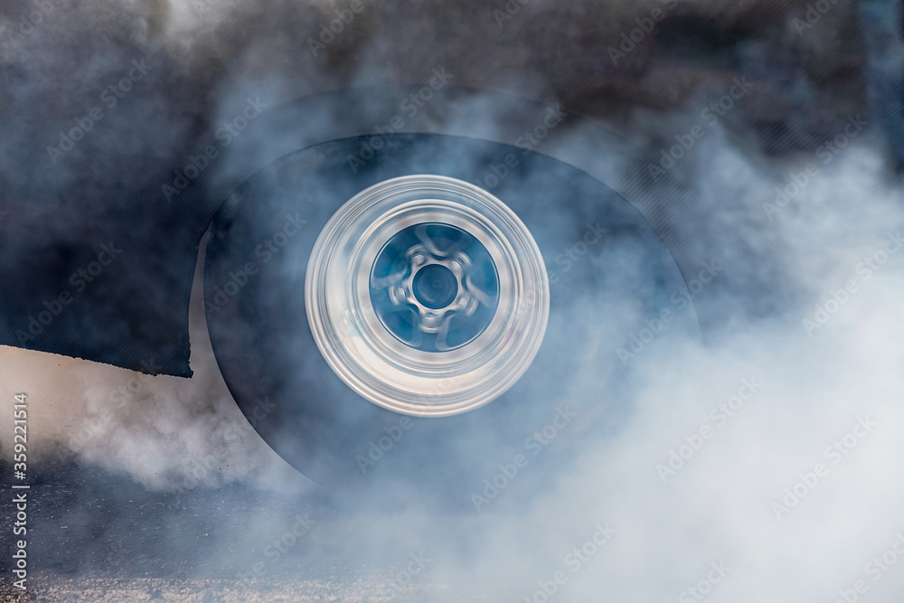 Wall mural drag racing car burns rubber off its tires in preparation for the race