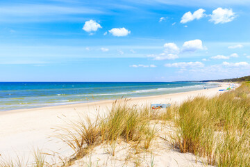 Fototapeta na wymiar Beautiful white sand beach with dunes and blue sea near Kolobrzeg, Baltic Sea coast, Poland