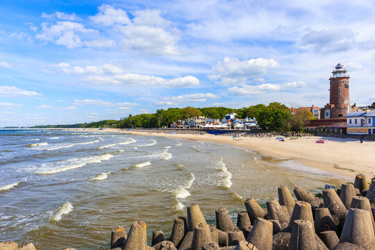 Lighthouse and beautiful white sand beach and blue sea in Kolobrzeg, Baltic Sea coast, Poland