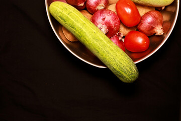 Vegetables in a steel bowl with black background