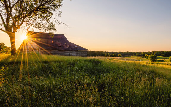 An old  abandoned barn under sunset with sunburst, sunstars
