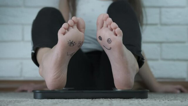 Feet with funny faces. Funny faces are painted on the child's feet.