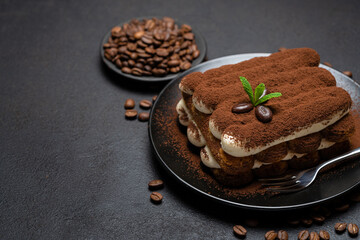 Classic tiramisu dessert on ceramic plate on concrete background