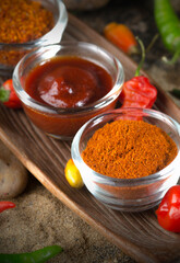 Chili in powder, sauce, and piece in a glass bowl. Close up with a depth of field.  bokeh effect
