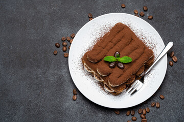 Classic tiramisu dessert on ceramic plate on concrete background