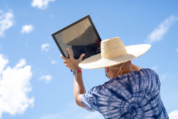 man viewing a solar eclipse via DIY telescope with indirect observation method