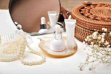 Dressing table with luxury cosmetic and skincare set, Cosmetic bottle containers with marine pearl extraction essence, Blank label for organic branding mock-up, Natural beauty product.