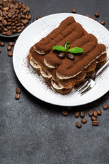 Classic tiramisu dessert on ceramic plate on concrete background