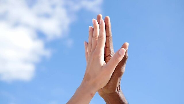 Friendship, anti-racism, fraternity-white hand and black hand are given the five. Stop racism, all people are equal. White and black hand connect. Friendship of Peoples.