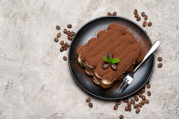 Classic tiramisu dessert on ceramic plate on concrete background