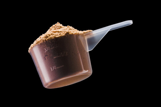 A scoop of chocolate protein powder drink isolated on black background