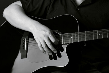 Professional musician playing acoustic guitar in music recording studio.