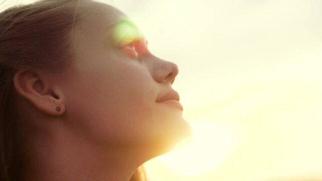 happy girl teen child closed her eyes dreams. teenager kid wants a dream come true portrait at sunset. woman daughter silhouette dreaming of a happy childhood. free face sister side view thinks