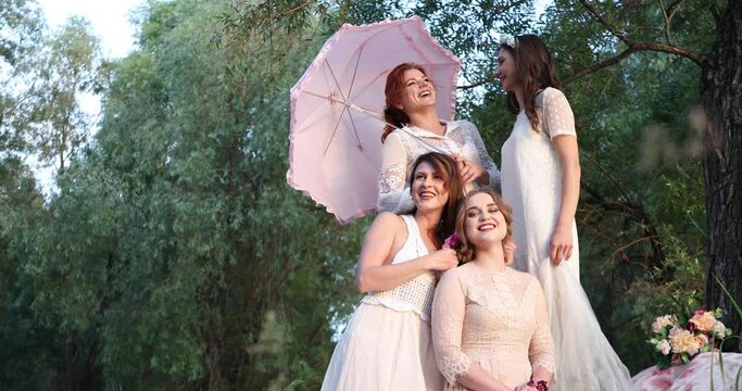 four girls in white vintage dresses in a forest on a picnic
